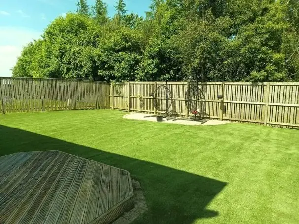 Restored artificial lawn beside a timber deck, green and even after cleaning