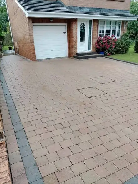 Freshly cleaned and re-sanded block paving driveway in front of a detached house